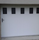 porte de garage en pvc coulissante avec hublots - teinte blanc