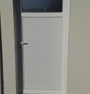 porte de service en pvc blanc avec oculus pour une entrée extérieure