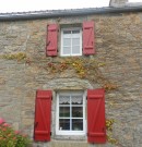 volets battants en aluminium à barres et écharpes - rouge brun - sur maison en pierre